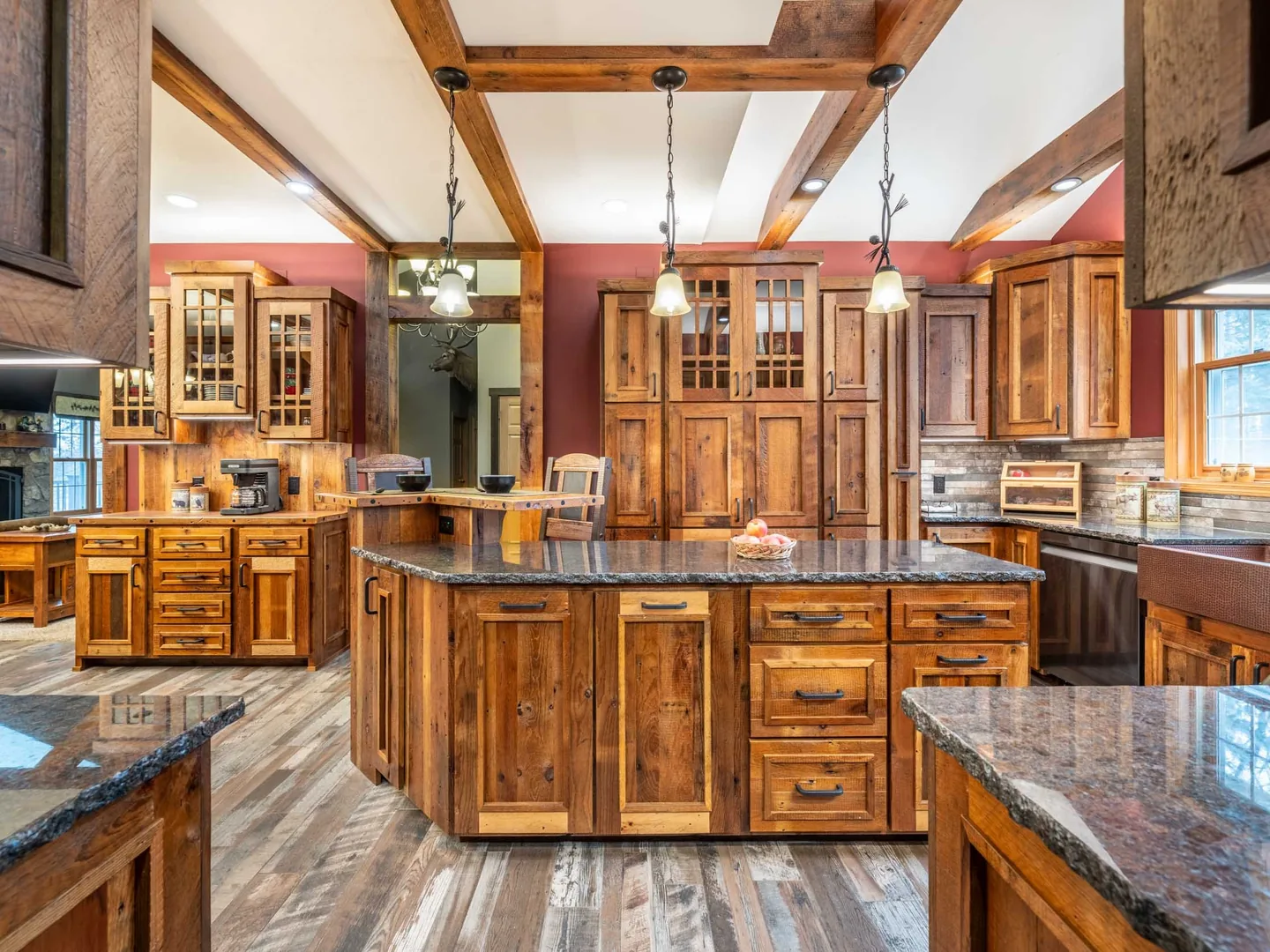 Kitchen remodeling with rustic wood cabinets, a wood island, dark granite counters and beamed ceiling