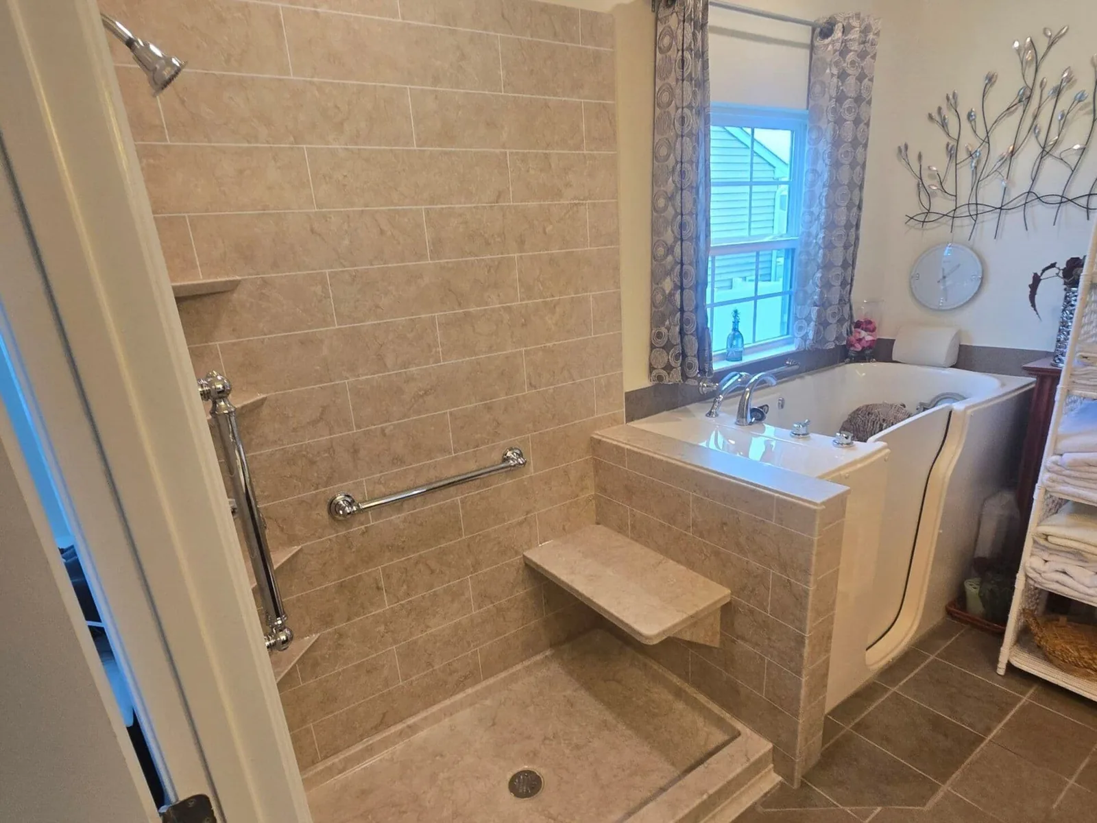 Walk in tubs: an installed walk in tub beside a low threshold tiled shower with grab bars and a corner seat